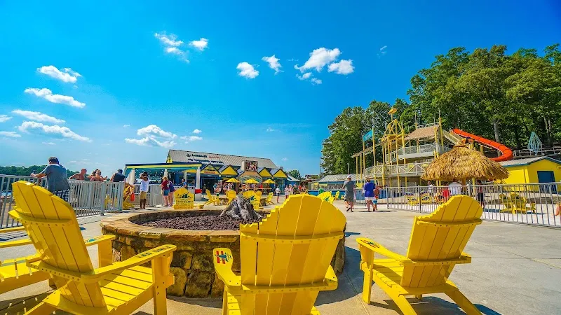 Yellow Adirondack chairs around fire pit at Margaritaville waterpark with slides