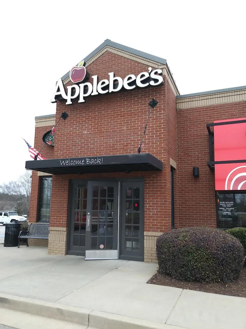 Brick Applebee's restaurant exterior with Welcome Back awning and American flag